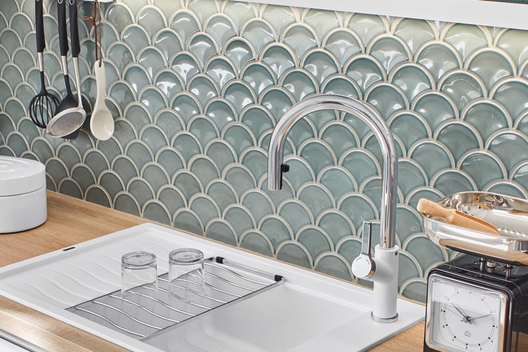 Diskho med armatur framför en vägg med fjällmönstrade plattor