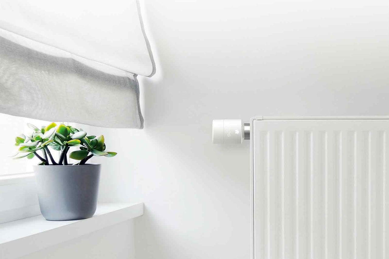 Element med termostat och krukväxt på fönsterbräda