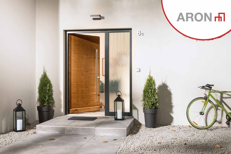 Ljus fasad med delvis öppen ytterdörr, dekoration och cykel