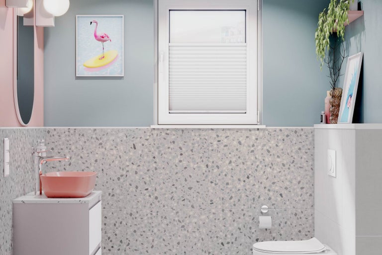 Modernt badrum med tvättställ, spegel, toalett och fönster med plisségardin