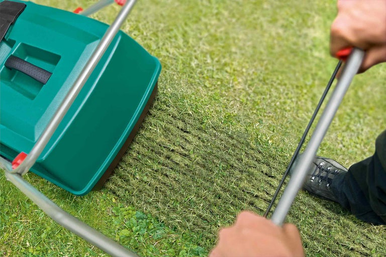 Gräsmattluftare i drift på en grön yta