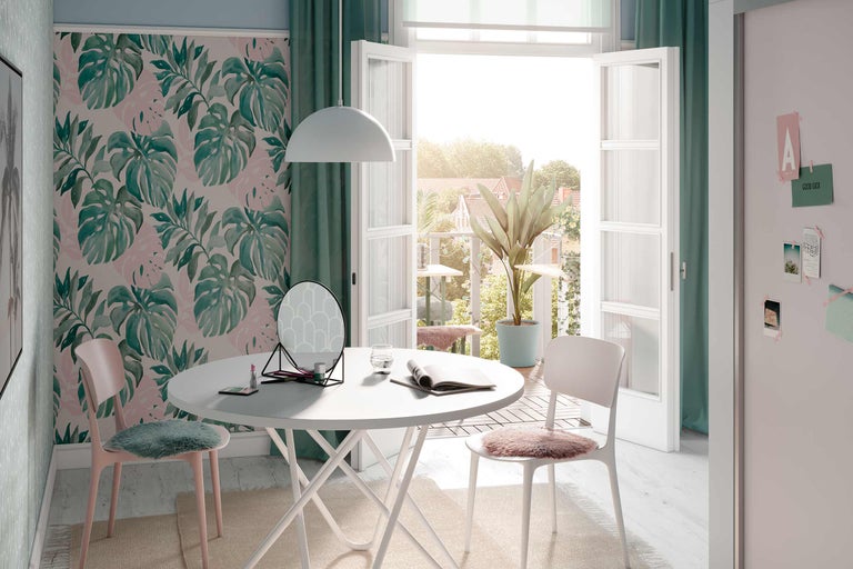Ljust rum med Monstera tapet, vitt bord, stolar, spegel och dekoration för en vänlig atmosfär.