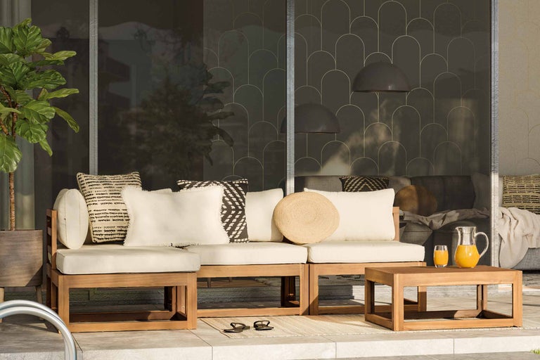 Uteplats med trämöbler, kuddar och sidobord med drycker