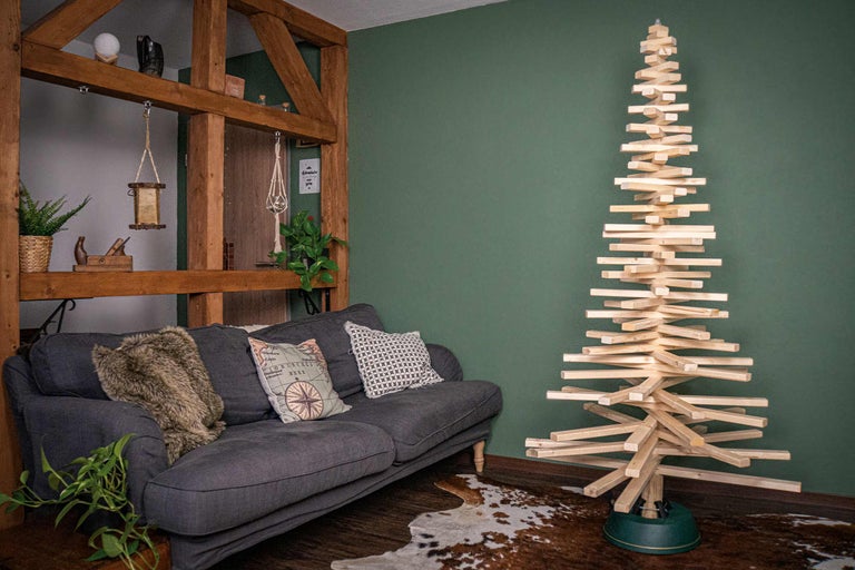 Dekorativt vardagsrum med soffa och julgran i trä
