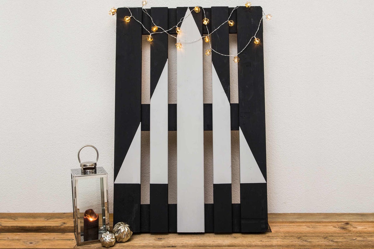 Dekorativ träbräda med julgransdesign, ljusslinga och ljuslykta för festlig atmosfär