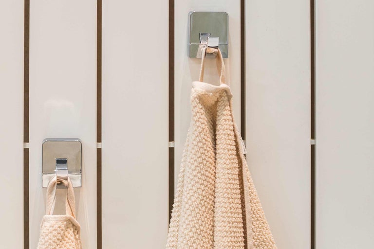 Handdukar på kromade krokar på en vägg