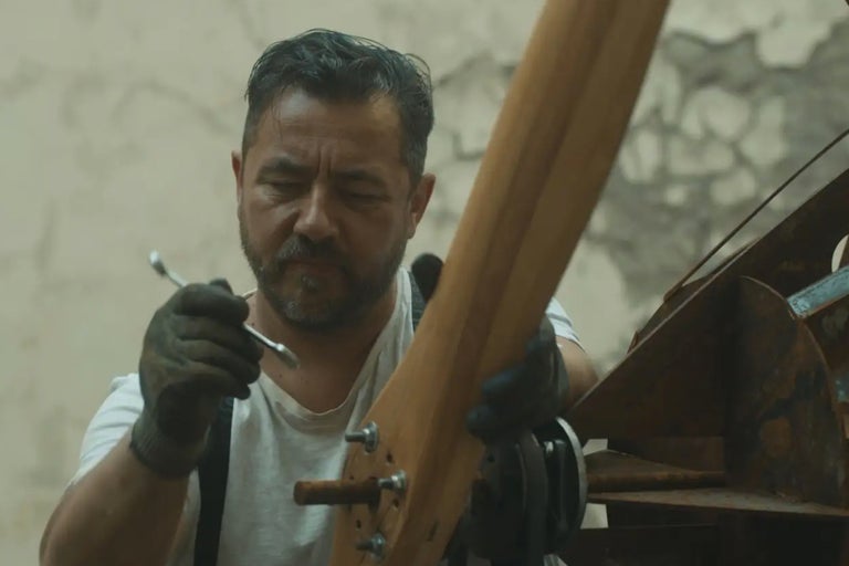 Man fäster en träpropeller med en skiftnyckel.