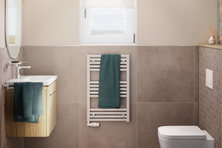 Ljust badrum med handfat, element med handduk och toalett