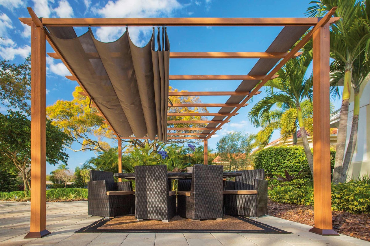 Pergola med utdragbart solskydd och trädgårdsmöbler på terrassen