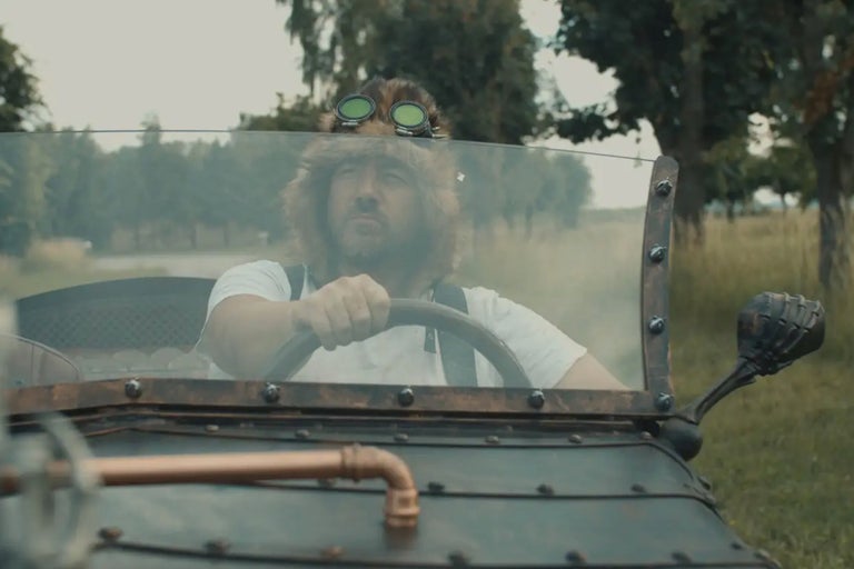 Man med pälsmössa och skyddsglasögon kör fordon i steampunkstil