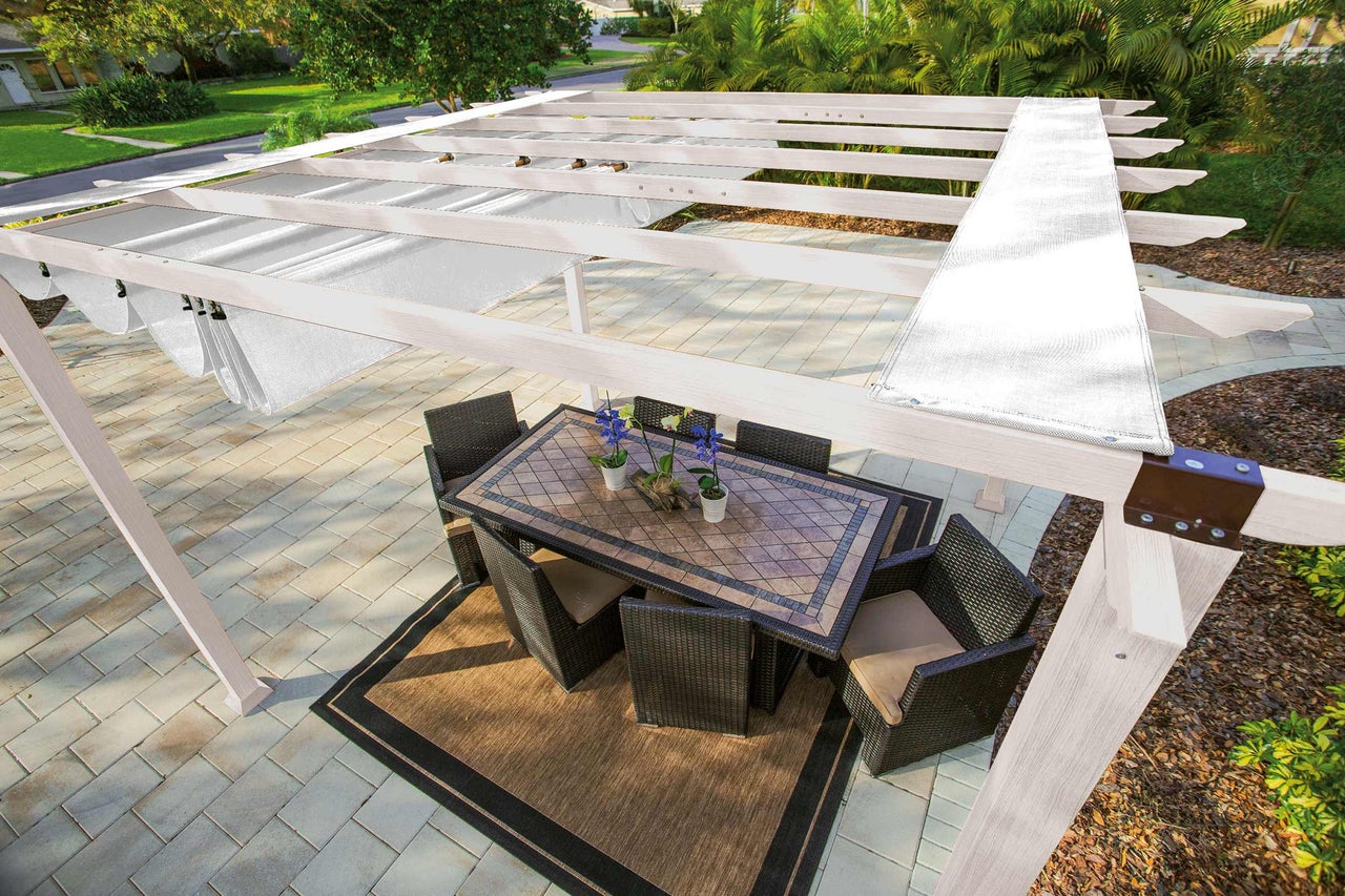 Pergola med solskydd, matbord och stolar på en terrass