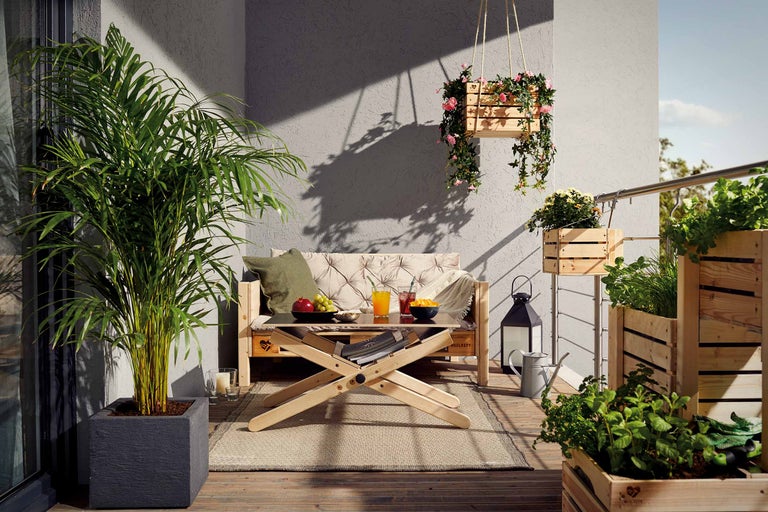 Dekorerad balkong med trämöbler och växter i planteringskärl