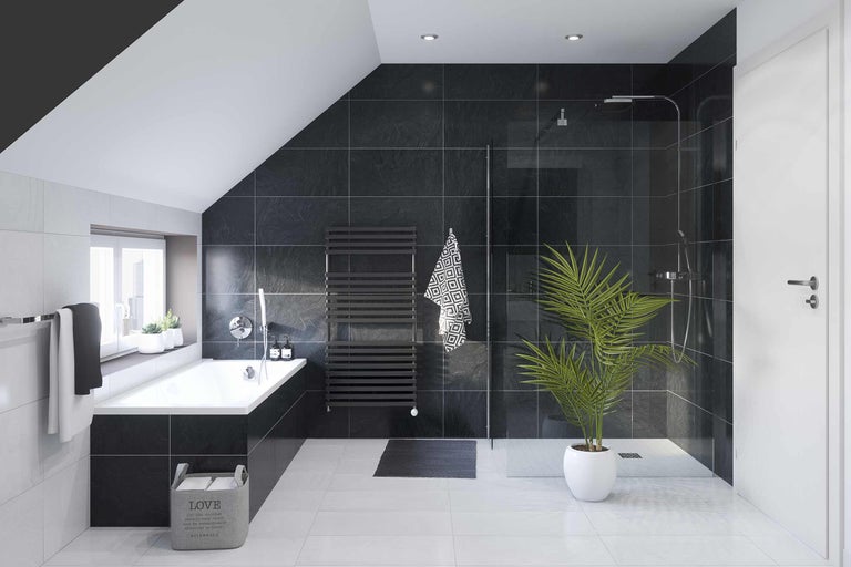 Badrum med badkar, dusch och mörka plattor