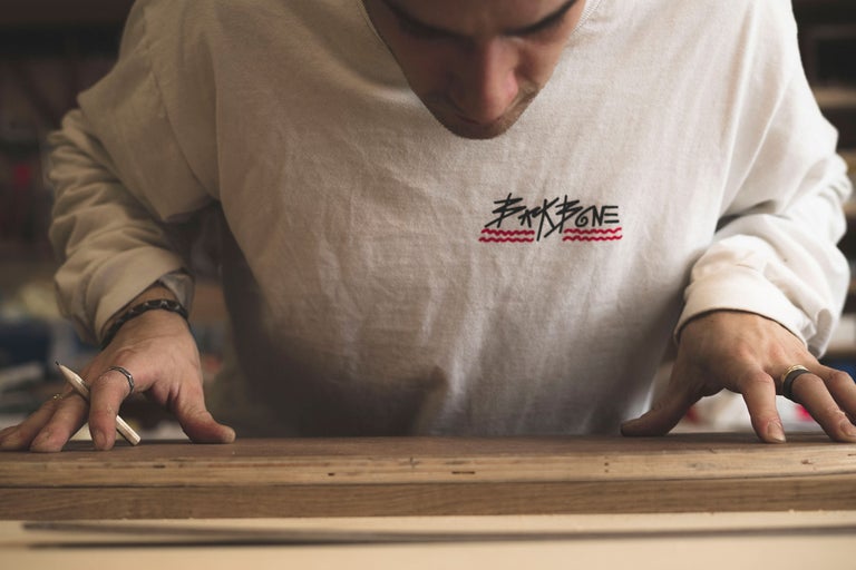 En person arbetar med trä och en blyertspenna.