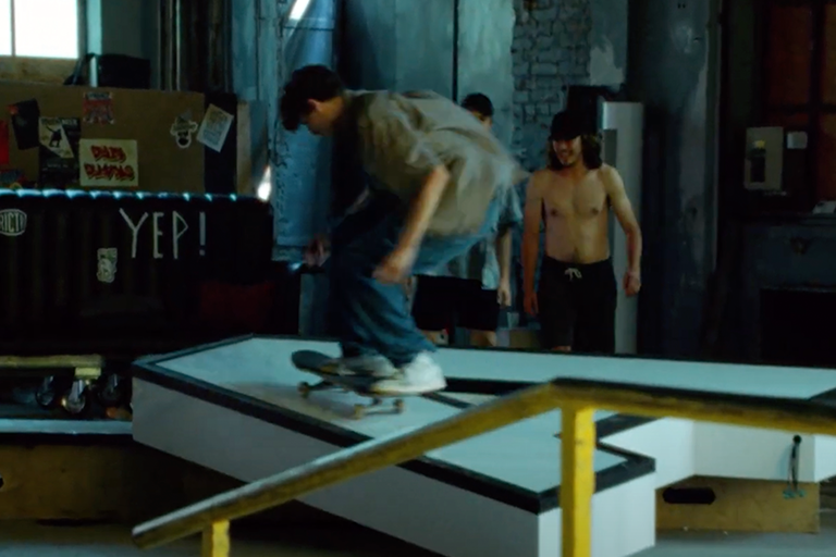 En ung man åker skateboard på en ramp i en skatepark.