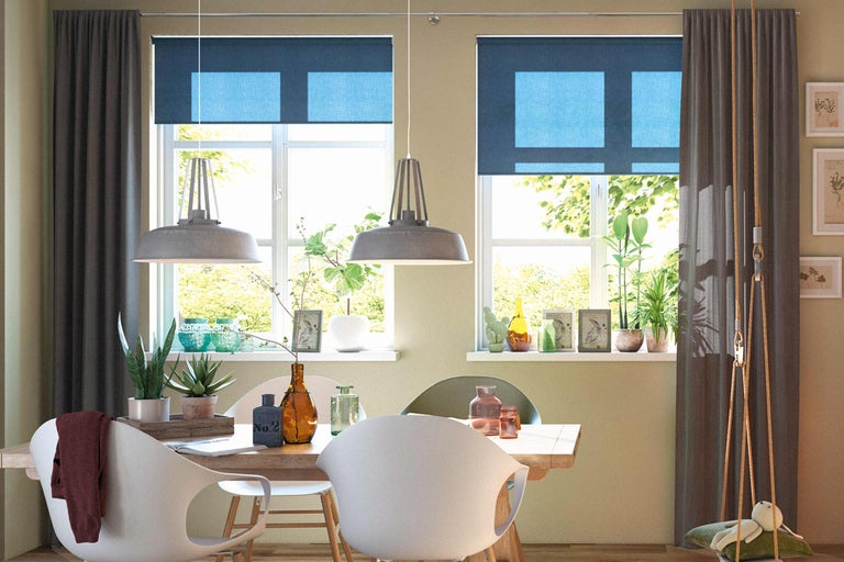 Matsal med matbord, stolar, fönster med rullgardiner och gardiner