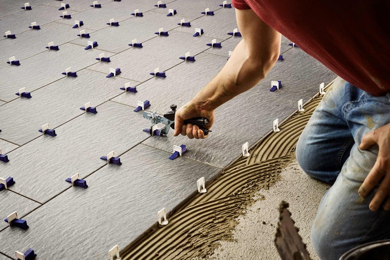 Läggning av golvplattor med kakelutjämningssystem och verktyg