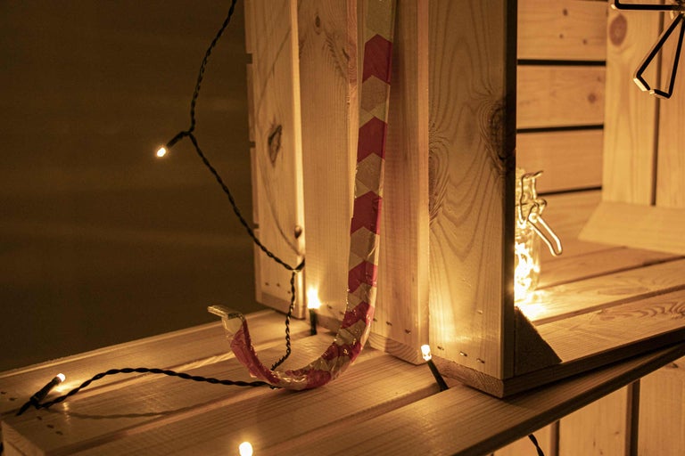 Trähylla med dekoration, ljusslinga och en dekoration med ett rött mönster