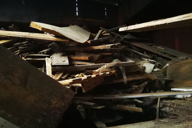 Hög med träavfall i mörk miljö