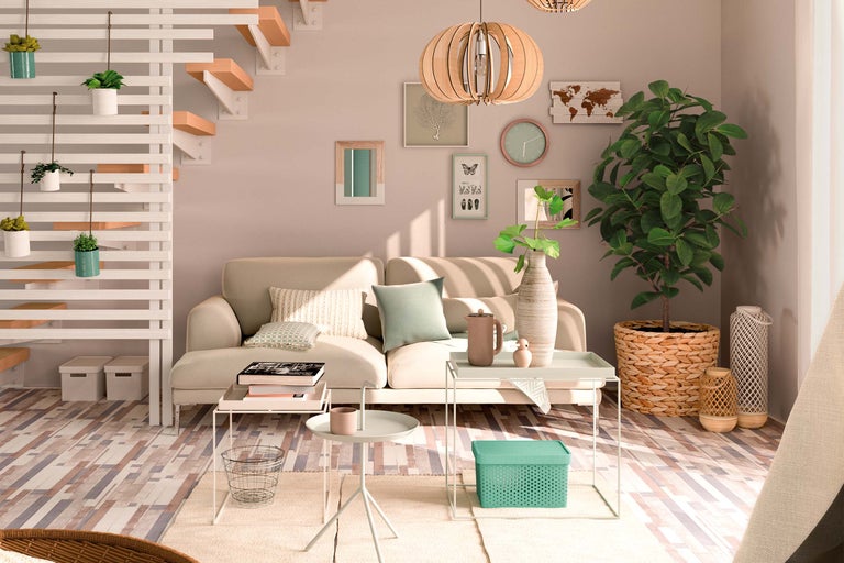 Ljust vardagsrum med soffa, sidobord, krukväxter och dekorativa element