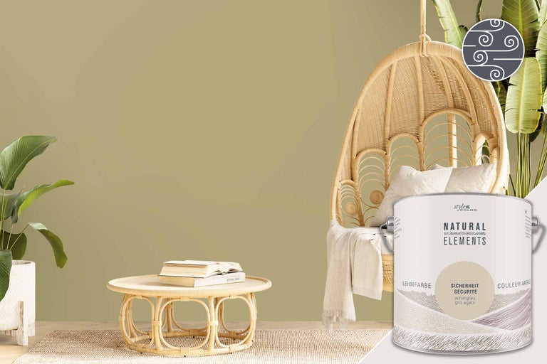 Rumsscen med en hink lerfärg, en rottingfåtölj och ett bord