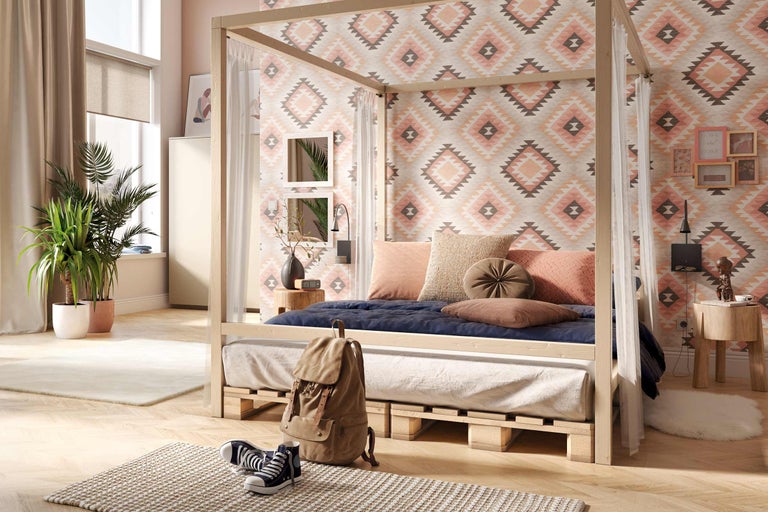 Sovrum med himmelssäng på träpallar och mönstrad tapet