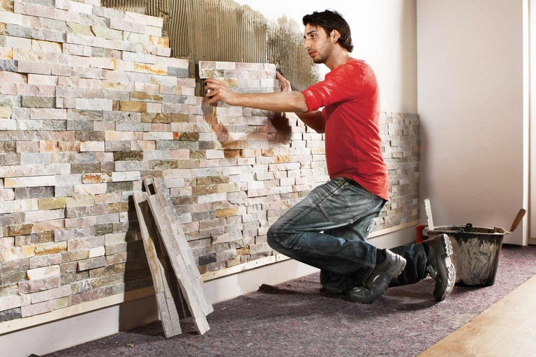 Man lägger naturstensbeklädnad på en innervägg