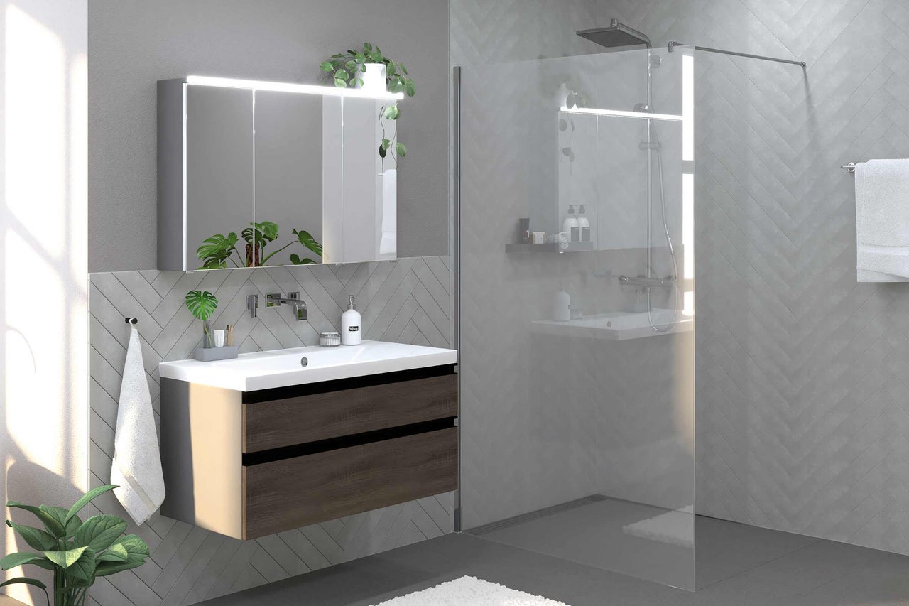 Modernt badrum med tvättställsskåp, spegelskåp med belysning och duschkabin