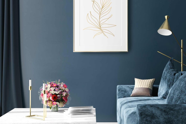 Vardagsrumsscen med soffa, bord, blomvas, ljusstake och väggdekoration