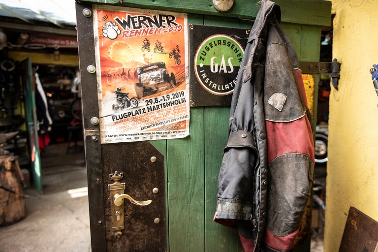 Dörr med Werner Rennen-affisch, skylt för godkänd gasinstallatör och jacka