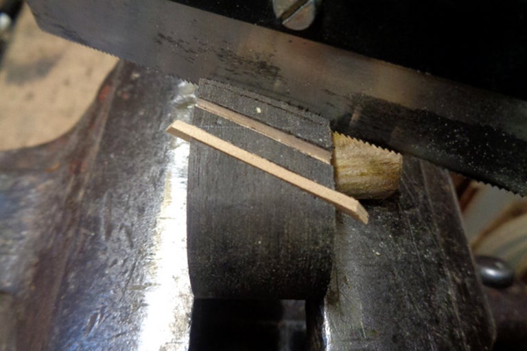 Metallsåg som sågar trä i skruvstycke