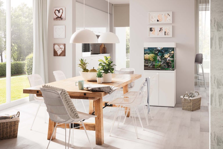 Ljus matplats med träbord, rottingstolar, akvarium och dekorationer