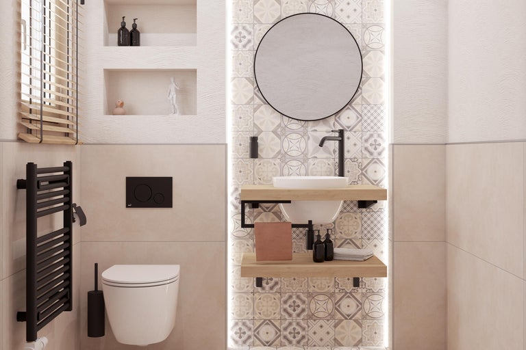 Ljust badrum med toalett, handfat, spegel och element