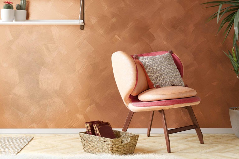 Dekorativt vardagsrum med fåtölj, kuddar, hyllor och växt