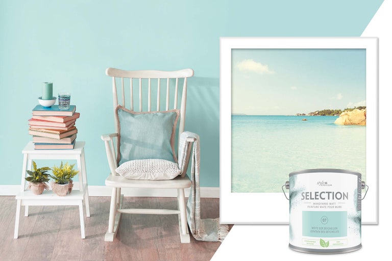 Dekorativt vardagsrum med färgburk, gungstol, väggmålning och sidobord