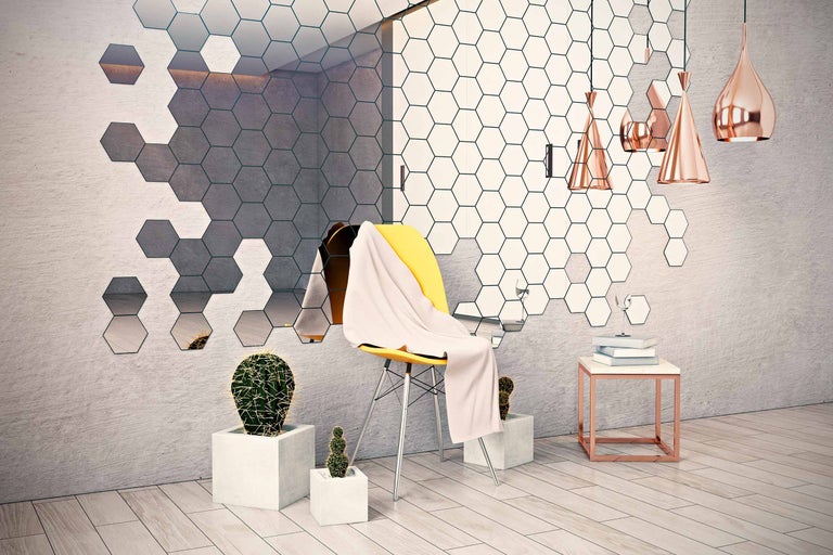 Vardagsrum med sexkantiga väggplattor, gul stol, kaktusar och pendellampor