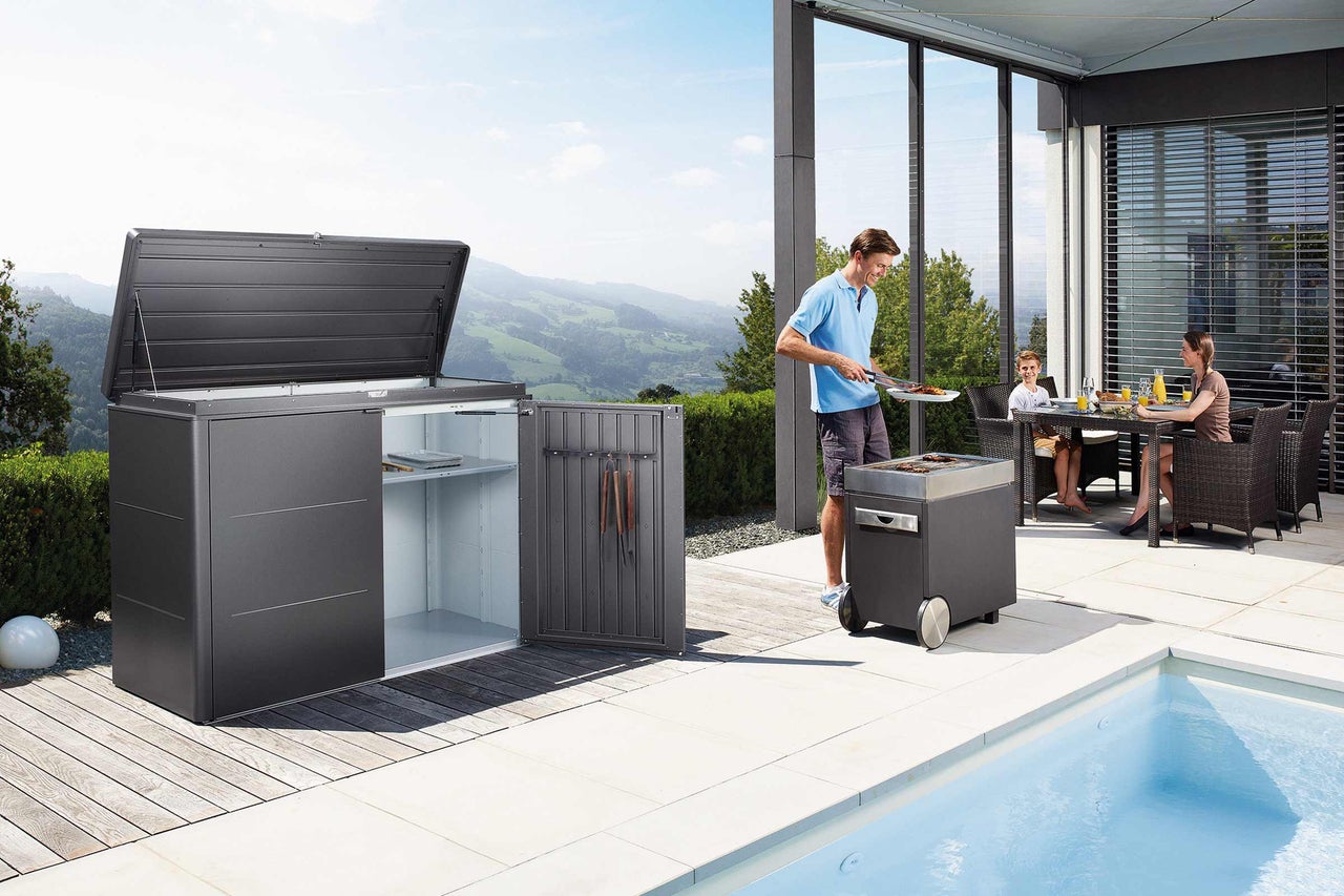 Terrass med förvaringsbox, grill och familj som äter utomhus