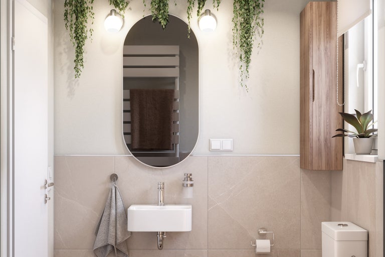 Ljust badrum med spegel, handfat, toalett och träskåp