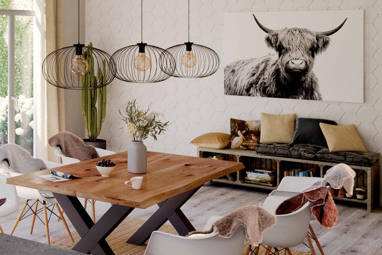 Matsal med träbord, hänglampor och kotavla på väggen.