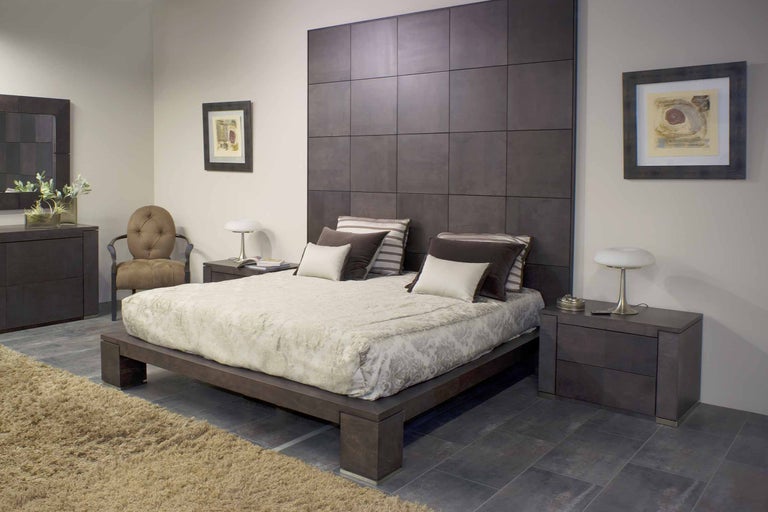 Sovrum med säng, sängbord, byrå och stol i ett ljust rum