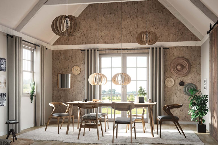 Matsal med matbord, stolar och hängande lampor i ett ljust rum.