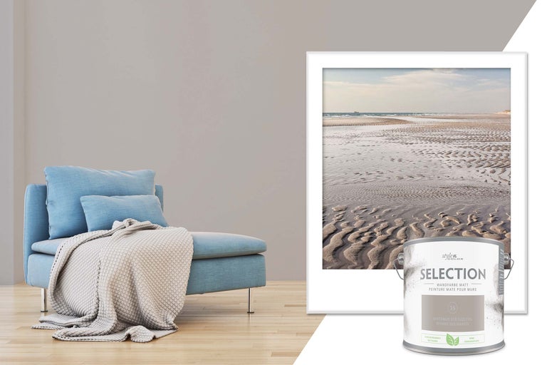 Vardagsrumsscen med färgburk, väggfärg, fåtölj och tavla