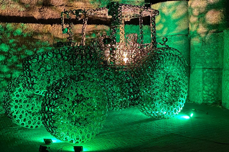 Dekorativ traktor skulptur gjord av metallringar med belysning