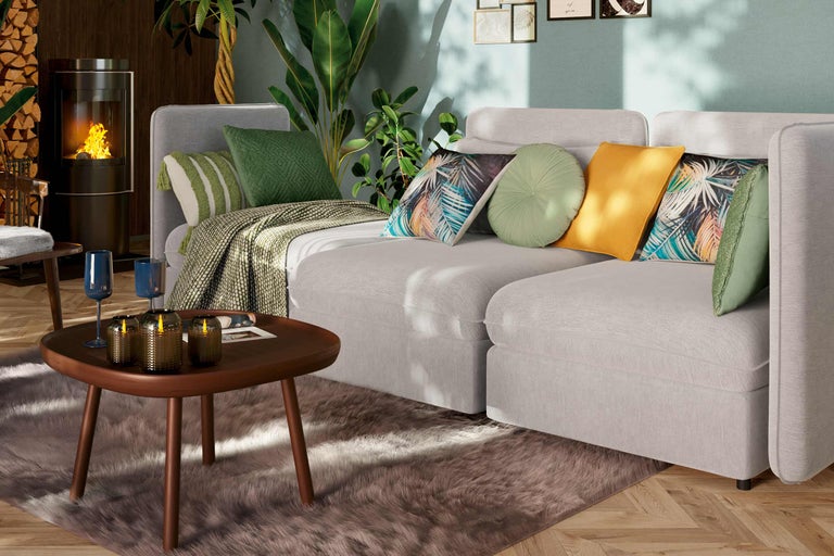 Vardagsrum med soffa, soffbord, öppen spis och krukväxter för en mysig atmosfär