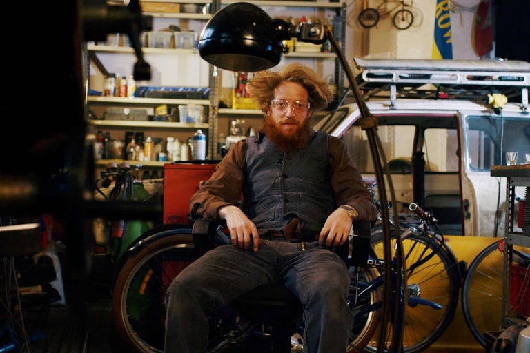 Verkstadsscen med en sittande person, cyklar och hyllor