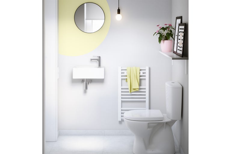 Modernt badrum med toalett, handfat, spegel och handdukstork för en ljus och organiserad atmosfär.