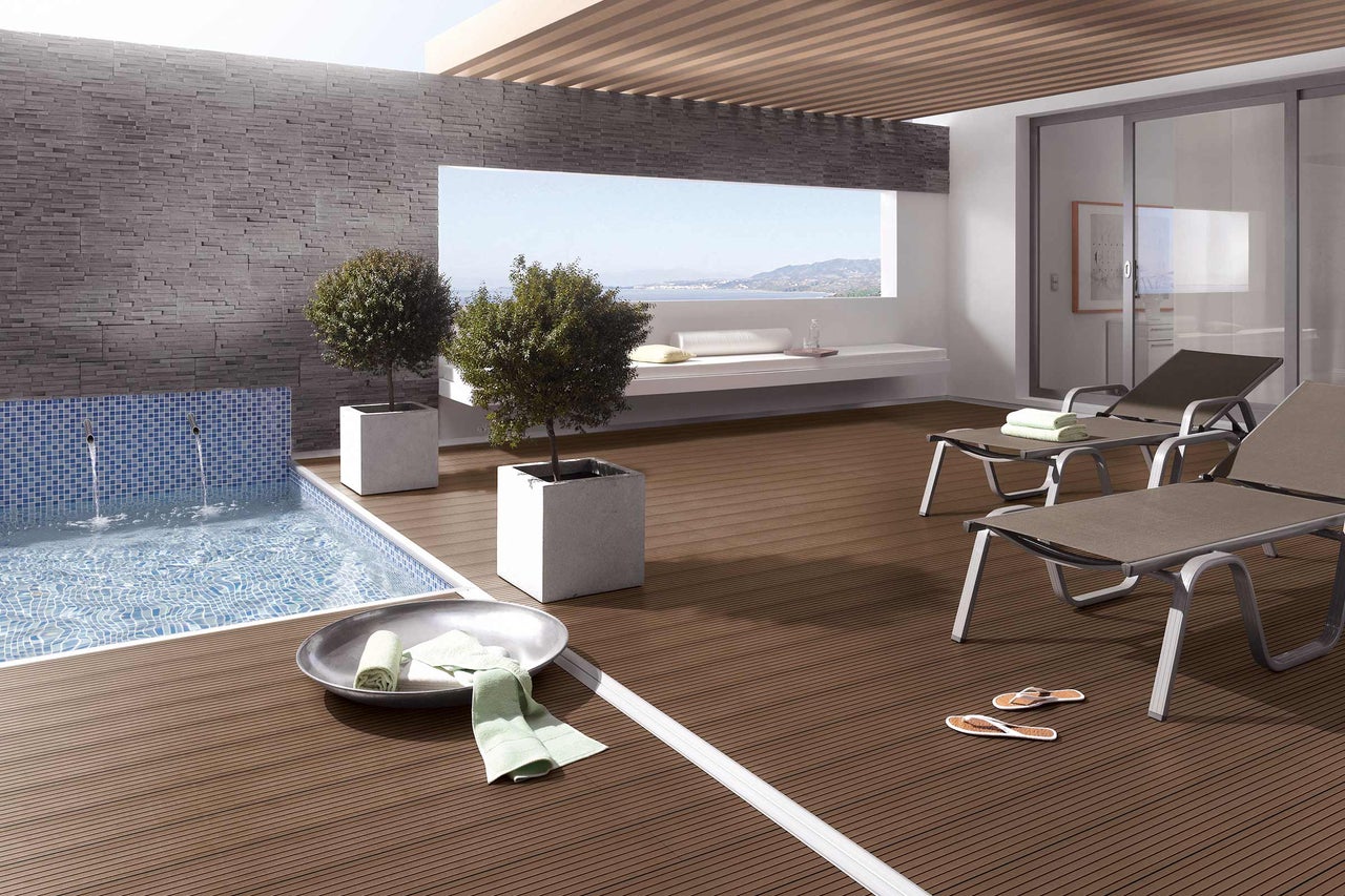 Terrass med träterrass, pool och solstolar