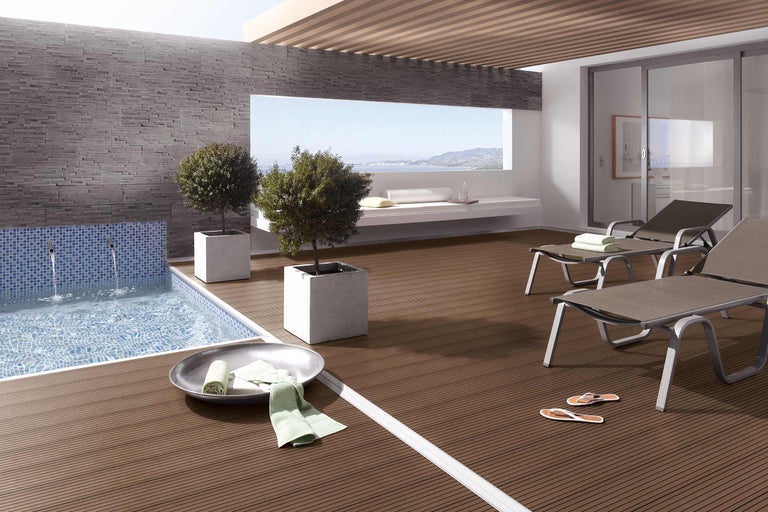 Terrass med träterrass, pool och solstolar