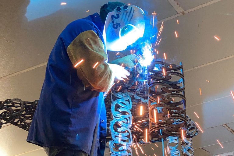 Svetsare som arbetar på en konstruktion av hästskor.