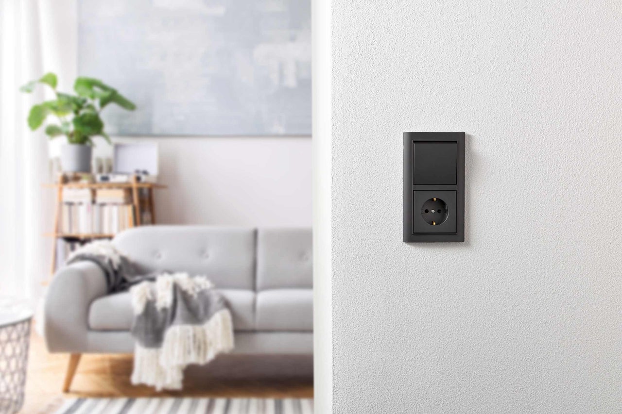 Strömbrytare och eluttag i ett modernt inrett vardagsrum.